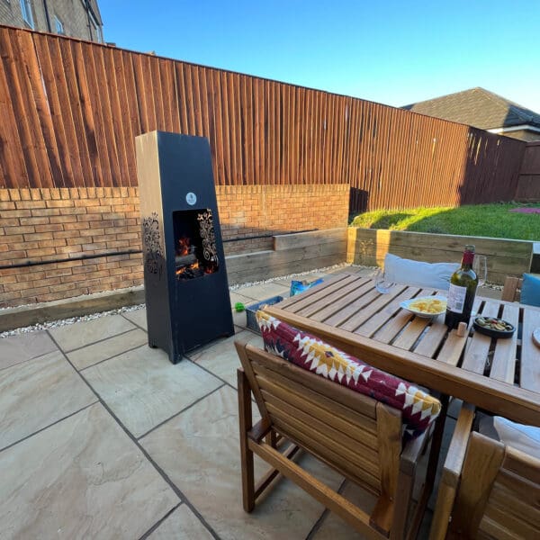 Tall metal chiminea next to wooden table square